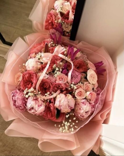 Peonies, garden roses and spray roses in pink wrap