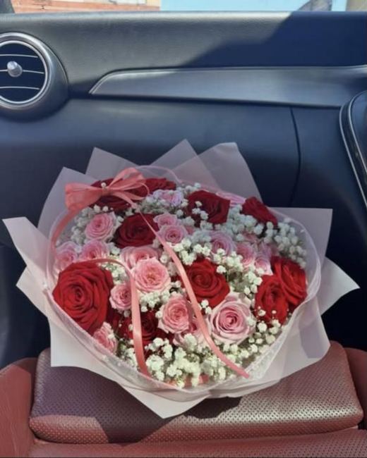 Red and pink roses with gypsophila in blush wrap